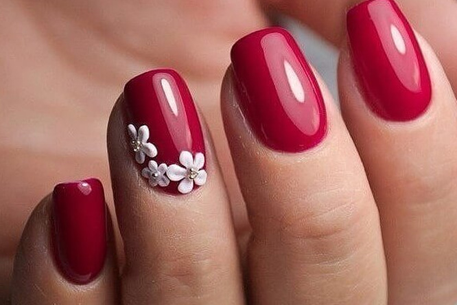 белые цветы на красных ногтях